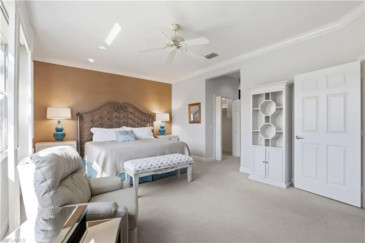 Crown molding, recessed lighting, ceiling fan, and carpeted flooring