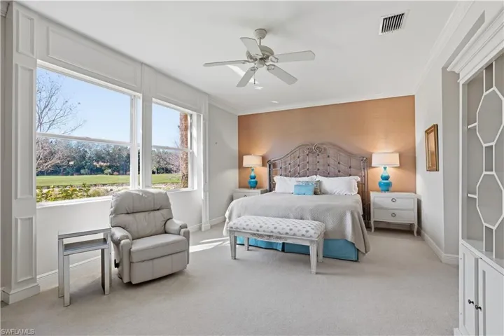 Large windows, crown molding, ceiling fan, accent wall, built-in cabinetry