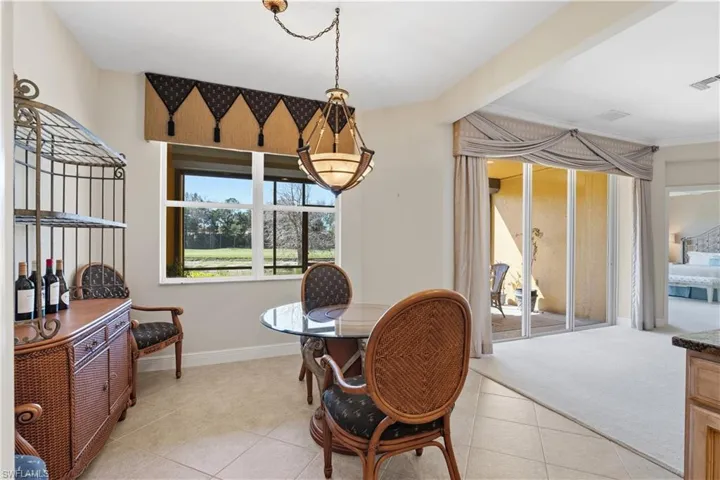 Tiled flooring extending into the living area with carpet, a large window providing natural light, and a built-in light fixture