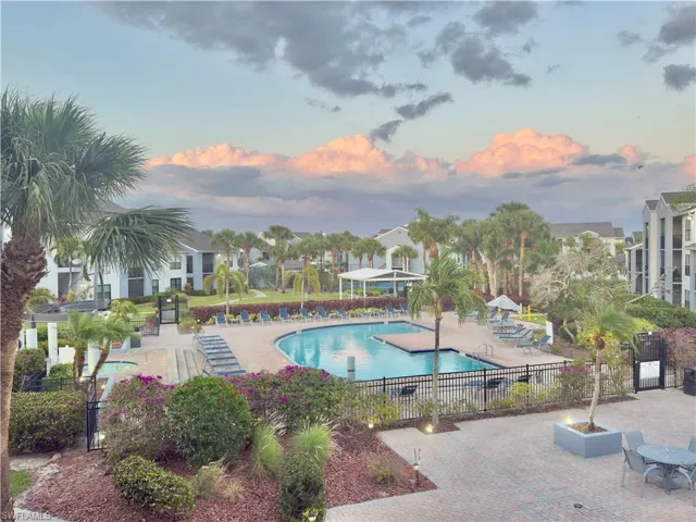 Community pool with a patio and fence