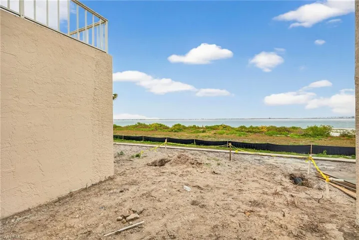 Unfinished patio with view of yard featuring a water view