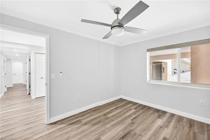 Bedroom featuring light wood-style flooring, ornamental molding, and ceiling fan