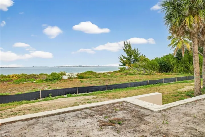 Unfinished patio with view of yard with a water view