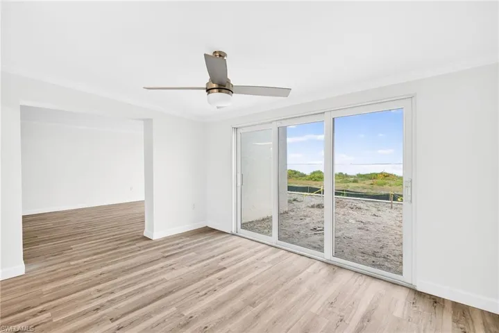 Spare room with crown molding, light wood-style floors, and ceiling fan