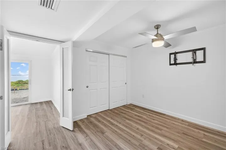 Unfurnished bedroom featuring light wood-style floors, a closet, ceiling fan, and ornamental molding