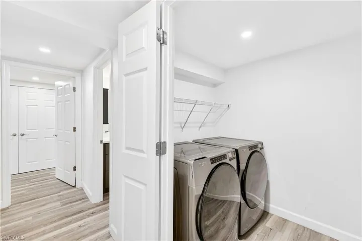 Laundry area featuring independent washer and dryer, light wood-type flooring, and recessed lighting