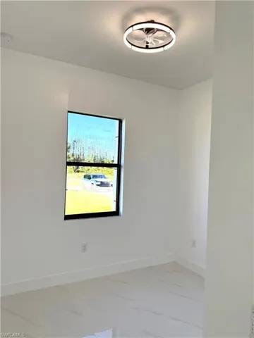 Empty room featuring baseboards and light marble finish floors