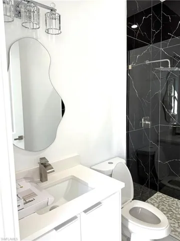 Full bathroom featuring vanity and a marble finish shower