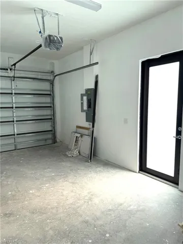Garage featuring electric panel and a garage door opener