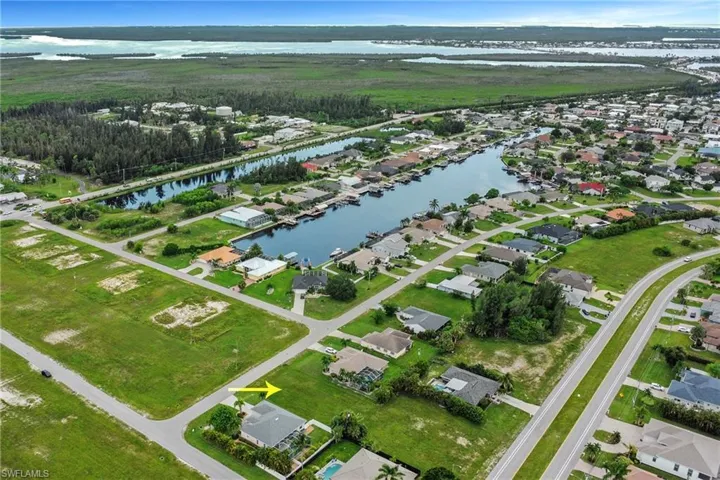 Aerial view of property's location with a nearby body of water and nearby suburban area