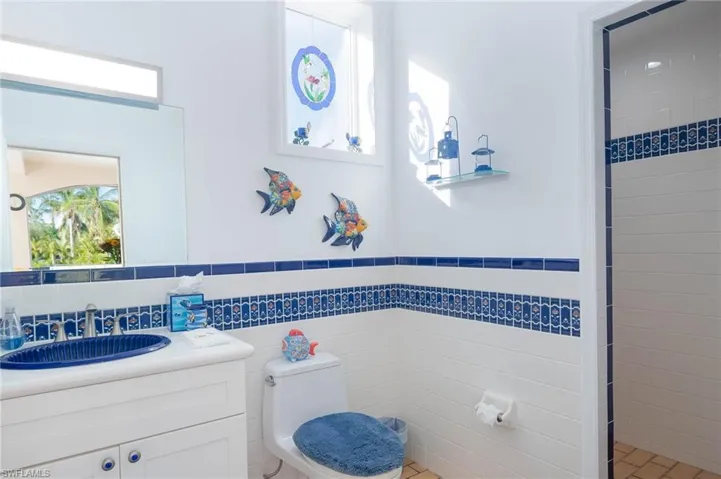 Outside pool bath with decorative tile and shower.