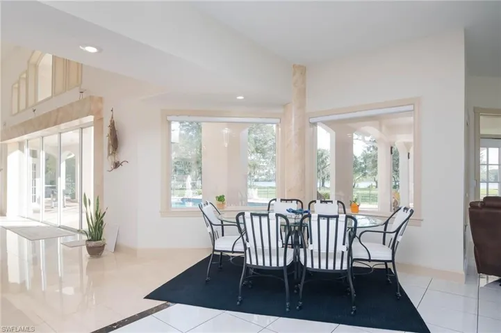 Dining area between kitchen and living room overlooking the grounds and pool.