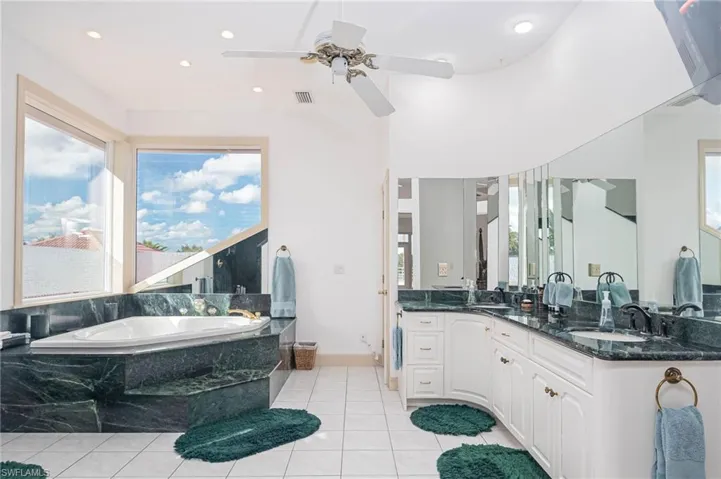 Luxurious Master suite with dual sinks, oversized spa tub, tile flooring, walk in shower and water closet.