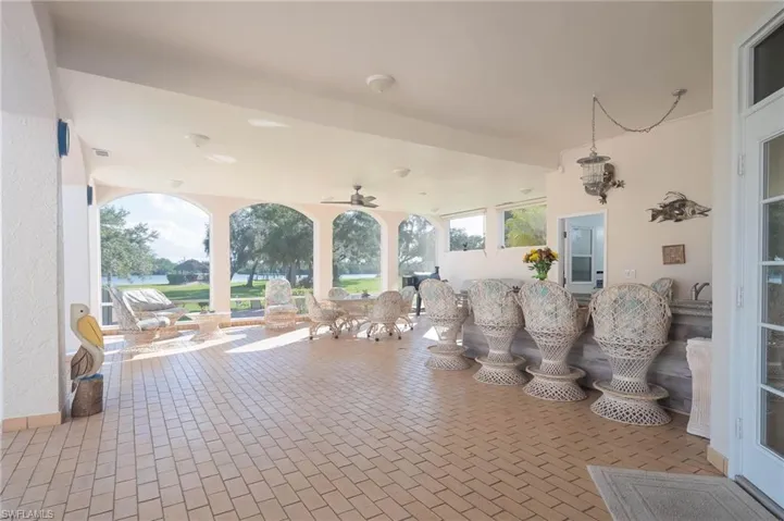 Large covered lanai features paver flooring, island with outdoor kitchen, sink, refrigerator, built in propane grill and TV.  Even a full bath with shower.