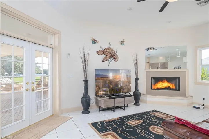 Cozy family room off of the kitchen with double french doors to lanai and pool area.  Wood burning fireplace for those cooler winter nights.