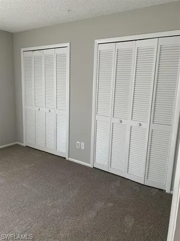 Unfurnished bedroom featuring carpet and a textured ceiling