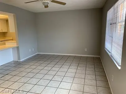 Empty room featuring ceiling fan and light tile patterned floors