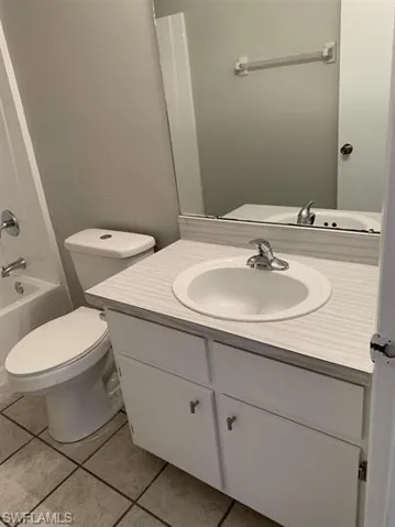 Full bathroom featuring tile patterned flooring, bathing tub / shower combination, toilet, and vanity