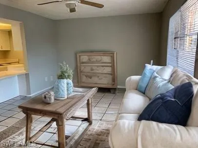 Living room with light tile patterned floors and ceiling fan