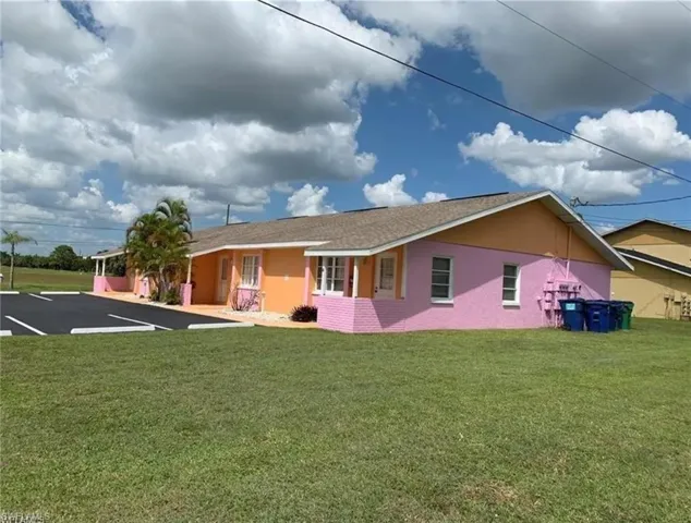 Back of property featuring a lawn