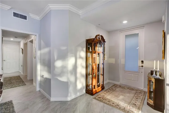 Foyer entrance featuring recessed lighting and crown molding