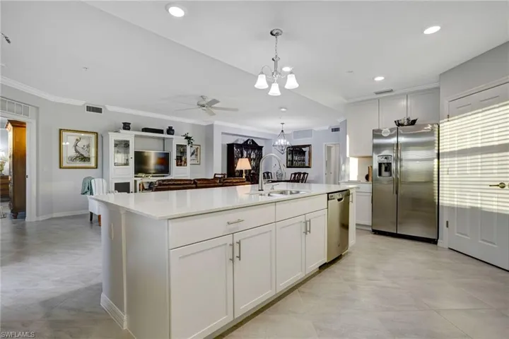 Kitchen featuring a chandelier, stainless steel appliances, ceiling fan, white cabinets, and ornamental molding