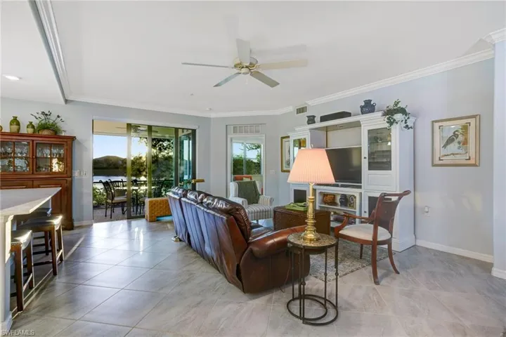 Living area with ceiling fan and ornamental molding