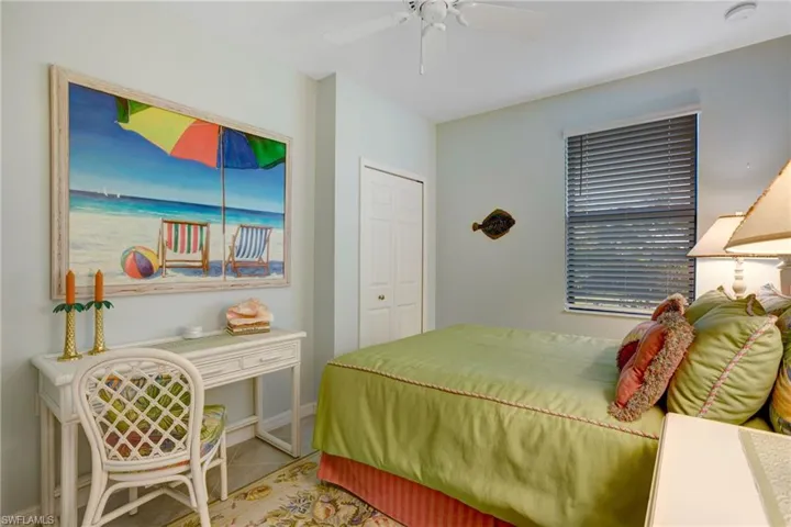 Tiled bedroom featuring a ceiling fan and a closet