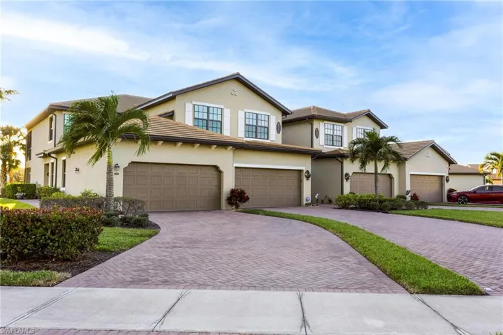 Traditional home with decorative driveway, stucco siding, and an attached garage