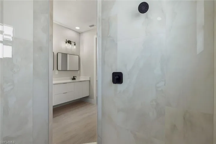 Bathroom with vanity, walk in shower, and hardwood / wood-style flooring
