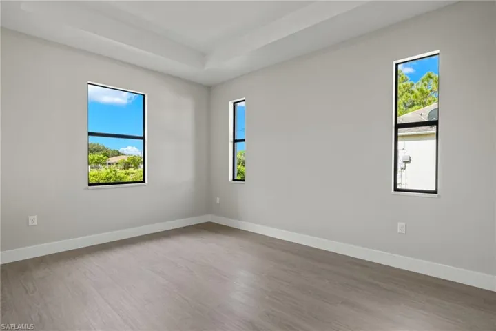 Unfurnished room featuring a healthy amount of sunlight and wood-type flooring