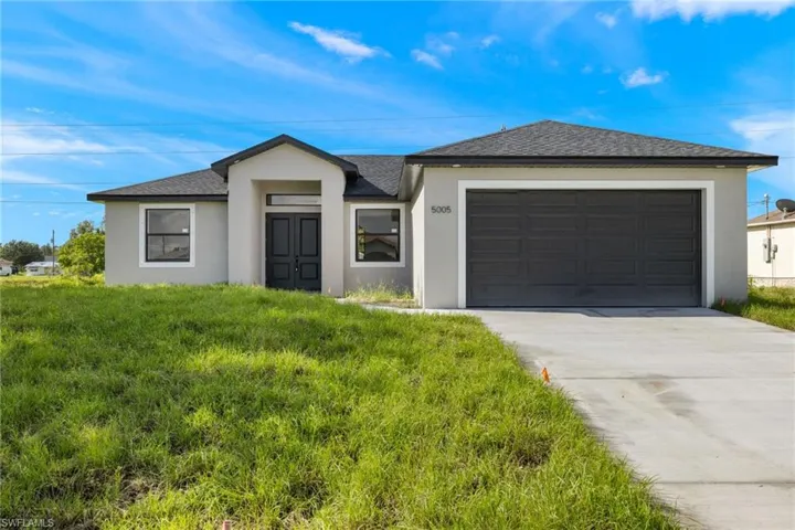 Single story home featuring a garage and a front yard