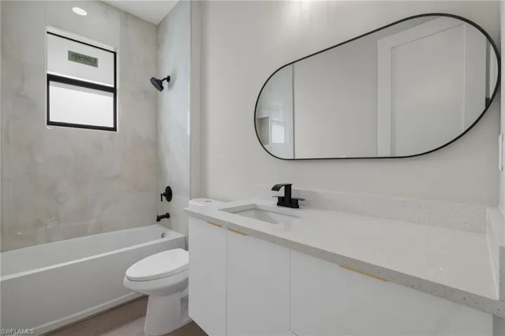 Full bathroom featuring vanity, toilet, hardwood / wood-style flooring, and tiled shower / bath