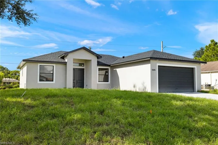 View of front facade with a garage and a front yard