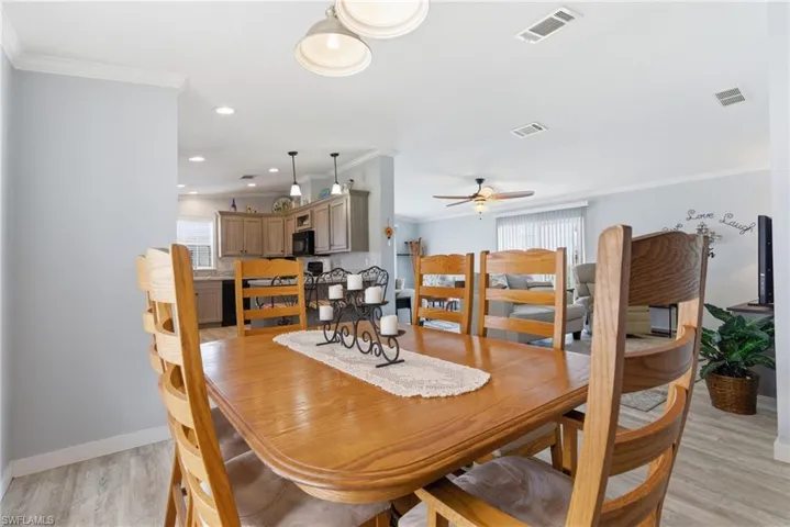 Dining area featuring ornamental molding, light wood-style floors, recessed lighting, and ceiling fan