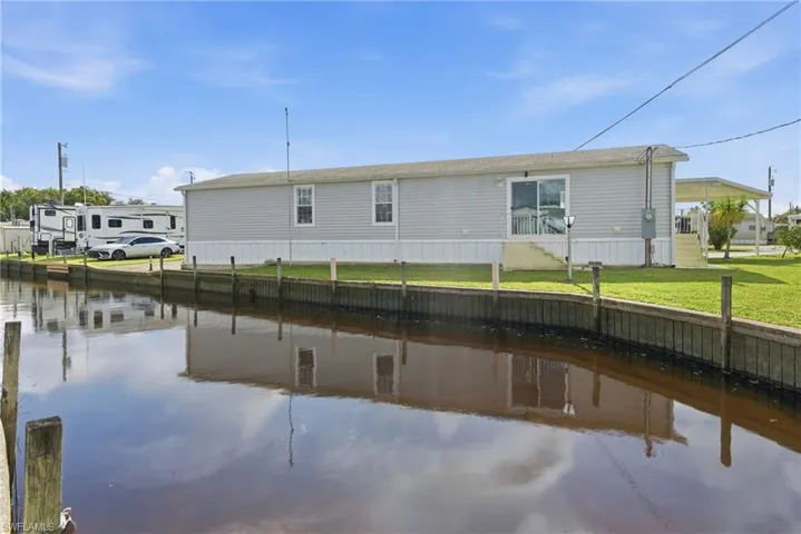Rear view of property featuring a water view and a yard
