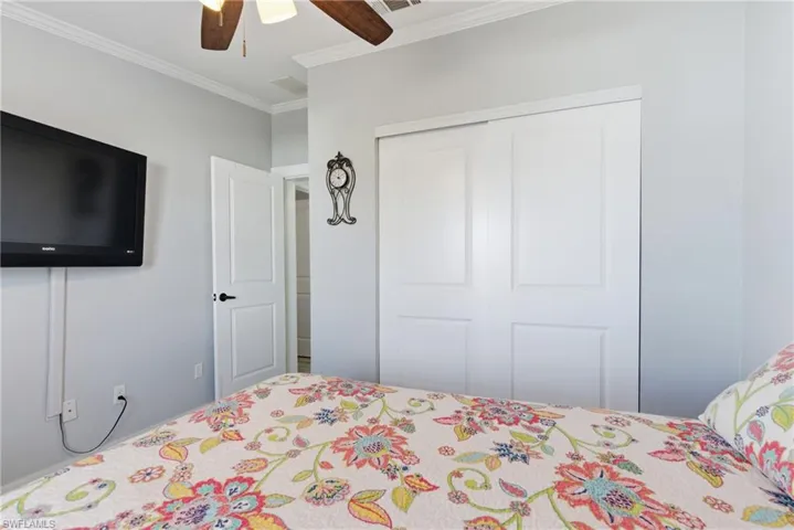 Bedroom with crown molding, a ceiling fan, and a closet