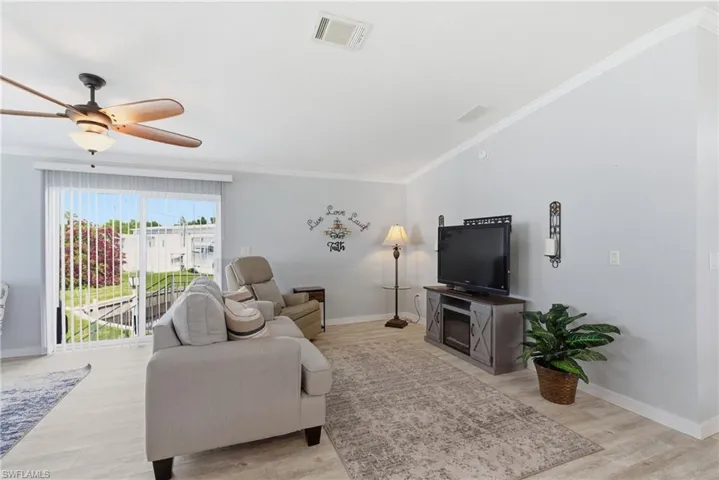 Living area featuring crown molding, ceiling fan, and light wood-type flooring