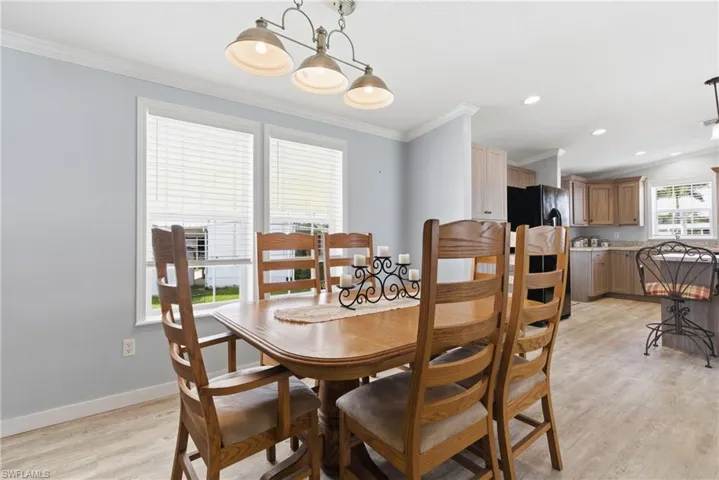 Dining space with light wood-style floors and ornamental molding