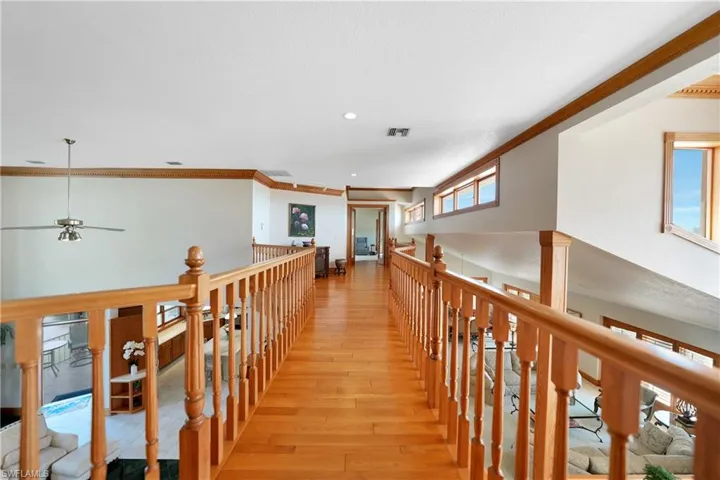 The bridge - featuring crown molding, light hardwood / wood-style flooring, and vaulted ceiling