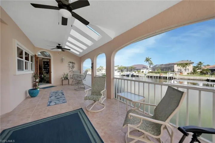 View of patio with ceiling fan and a water view