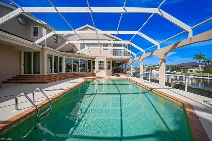 View of swimming pool featuring a lanai, a water view, and a patio area