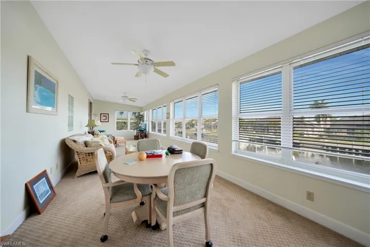 Sunroom / solarium with lofted ceiling, ceiling fan, and a wealth of natural light