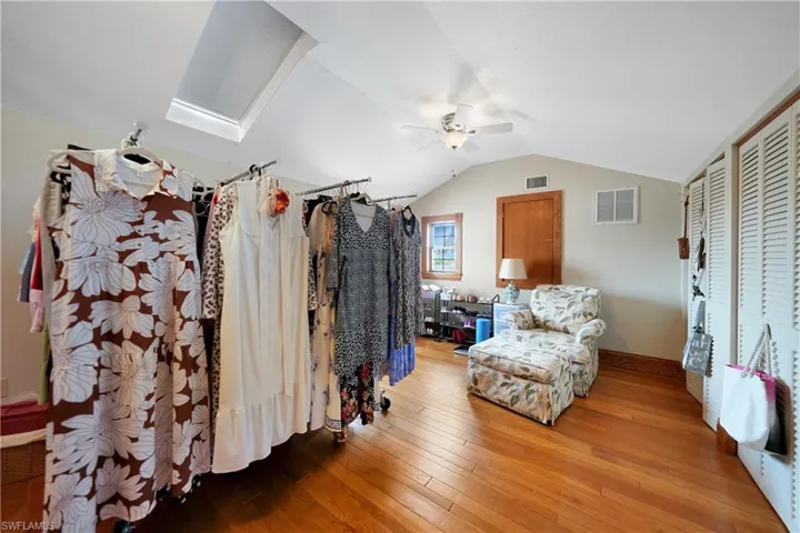 Bedroom with hardwood / wood-style floors, ceiling fan, and vaulted ceiling