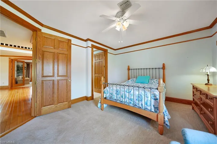 Carpeted bedroom featuring crown molding and ceiling fan