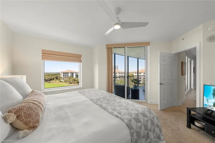 Bedroom featuring access to exterior, light colored carpet, and a ceiling fan