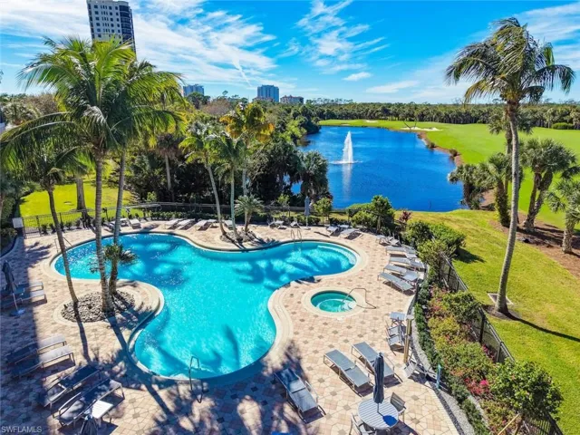 Community pool with a patio, a hot tub, and a water view