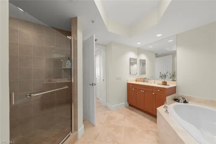 Bathroom with vanity, a bath, a stall shower, light tile patterned floors, and recessed lighting