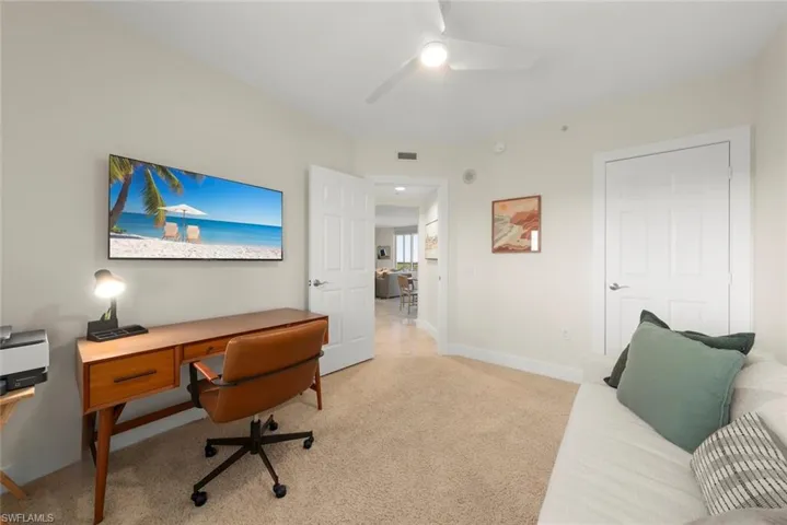 Office area featuring light colored carpet and ceiling fan