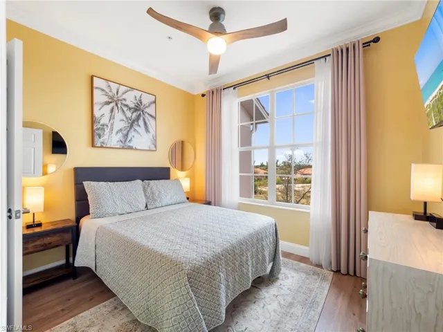Bedroom featuring crown molding, wood finished floors, and a ceiling fan